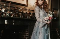 a grey A-line wedding dress with long sleeves, a high neckline and blush floral appliques