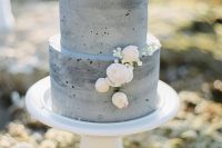 a grey concrete wedding cake with tender blush and white blooms is a stylish idea for a modern wedding