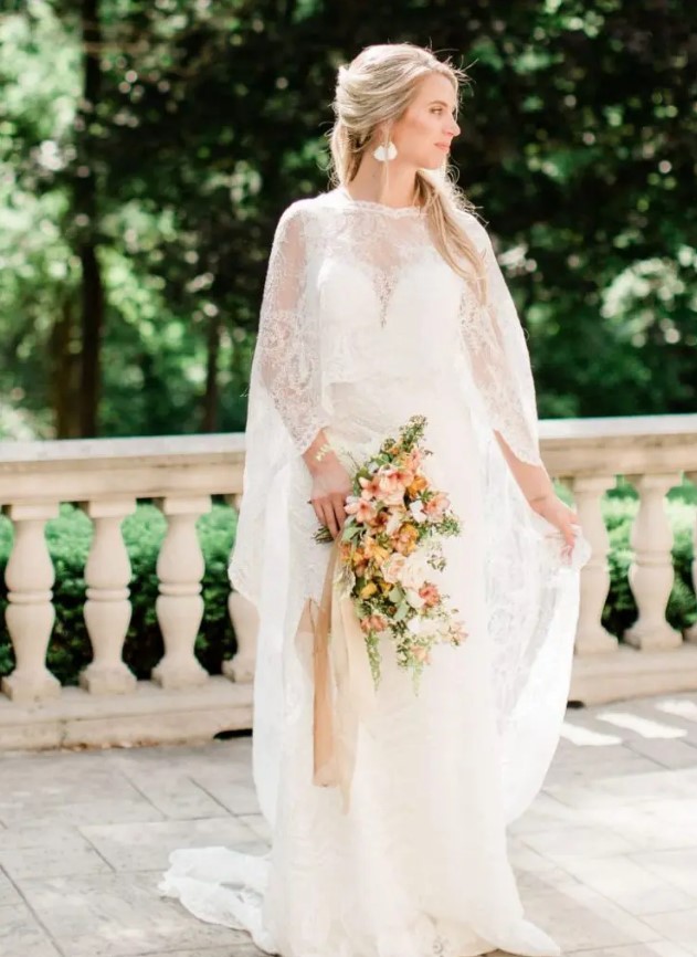 a lace A line wedding dress paired with a matching lace capelet and delicate earrings for a strong Old World feel