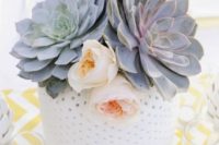 a large polka dot vase with large succulents and blush blooms is a cool and fresh wedding centerpiece idea