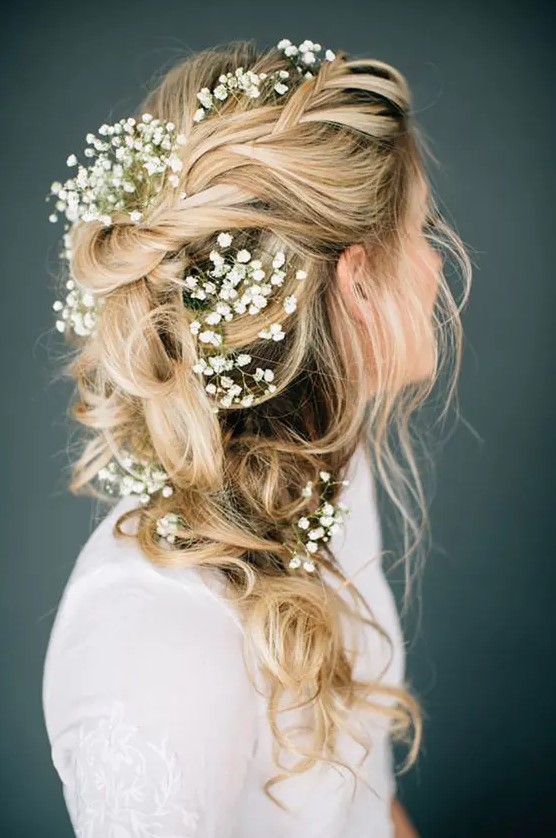 a messy braided ponytail with baby's breath tucked in and some locks down is a lovely idea for a spring or summer boho bride