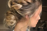 a messy braided updo with a low bun and locks down for a casual modern bride
