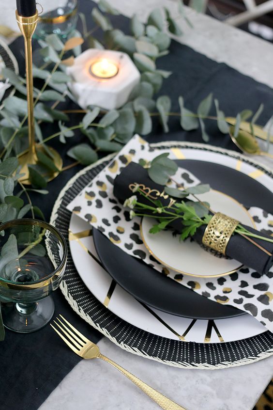 a monochromatic wedding tablescape with bold prints including leopard ones and gold touches is great for safari