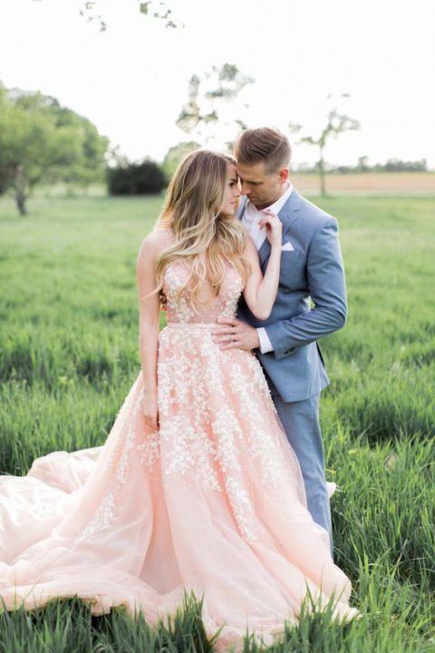 a pink sleeveless wedding dress with a plunging neckline and pearl floral embroidery all over the gown