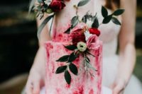 a pink watercolor wedding cake decorated with pink and red blooms and foliage is a bold modern idea