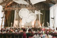 a refined and chic wedding venue decorated with paper planes and cardboard clocks