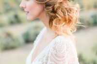 a romantic and wavy side updo with a volume on top and an air plant and berry hairpiece for an accent