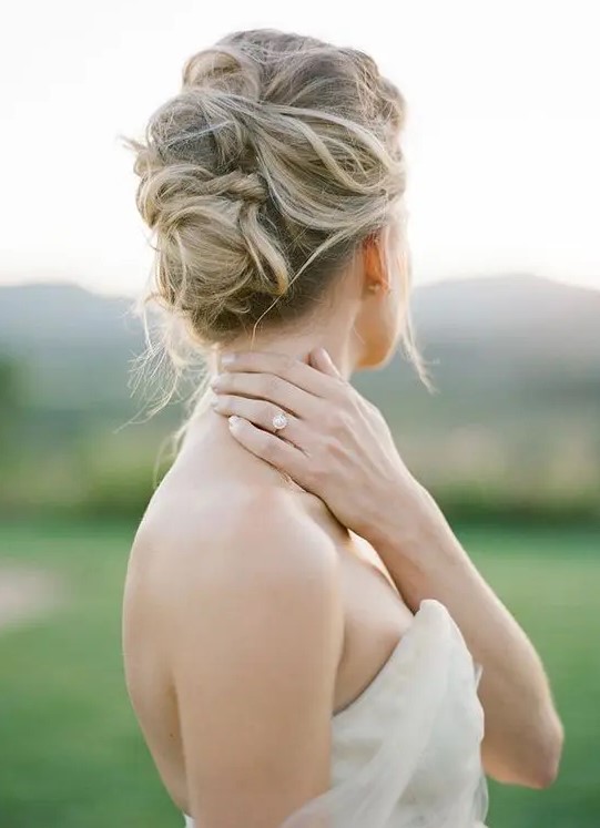a soft and messy bridal updo looks chic and doesn't require much effort to make