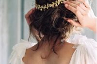 a super rmessy and curly updo accented with a beautiful gold headpiece is a lovely idea for a romantic bridal look