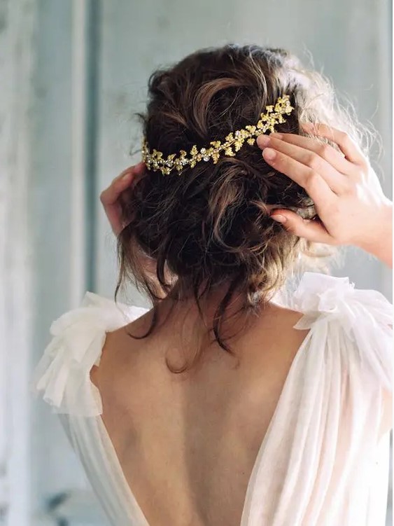 a super rmessy and curly updo accented with a beautiful gold headpiece is a lovely idea for a romantic bridal look