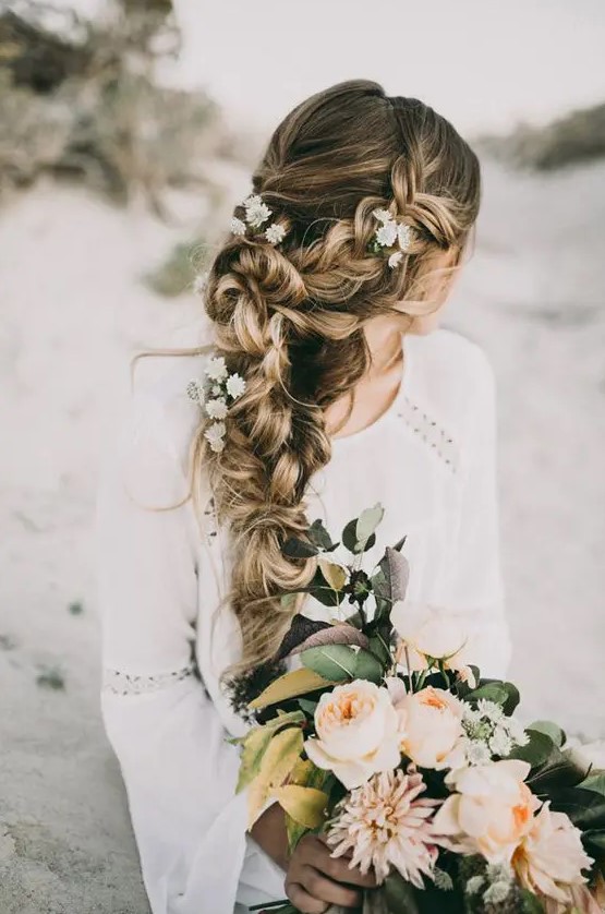 a very dimensional and textural braid made of two side ones with fresh flowers is a great destination hair solution