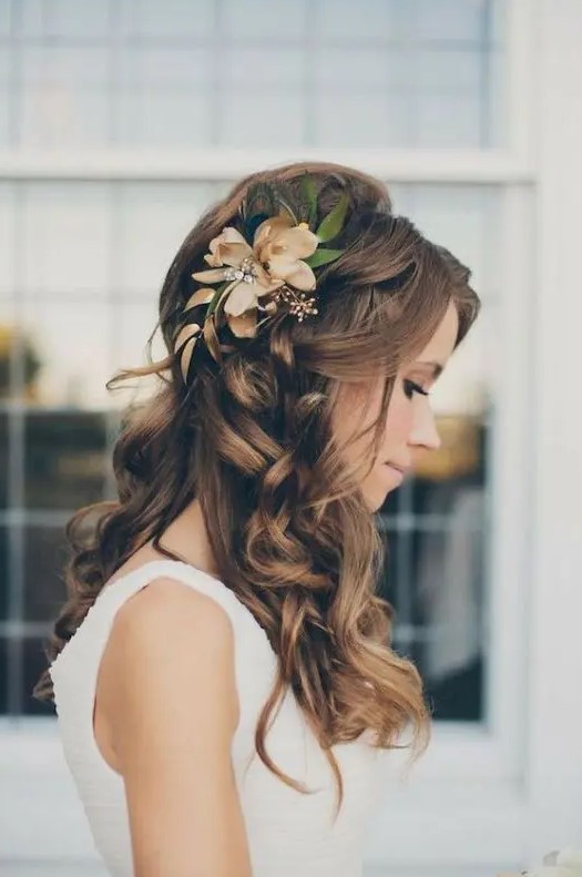 a wavy and curly hairstyle with faux blooms and greenery is a timeless and stylish idea for a bride