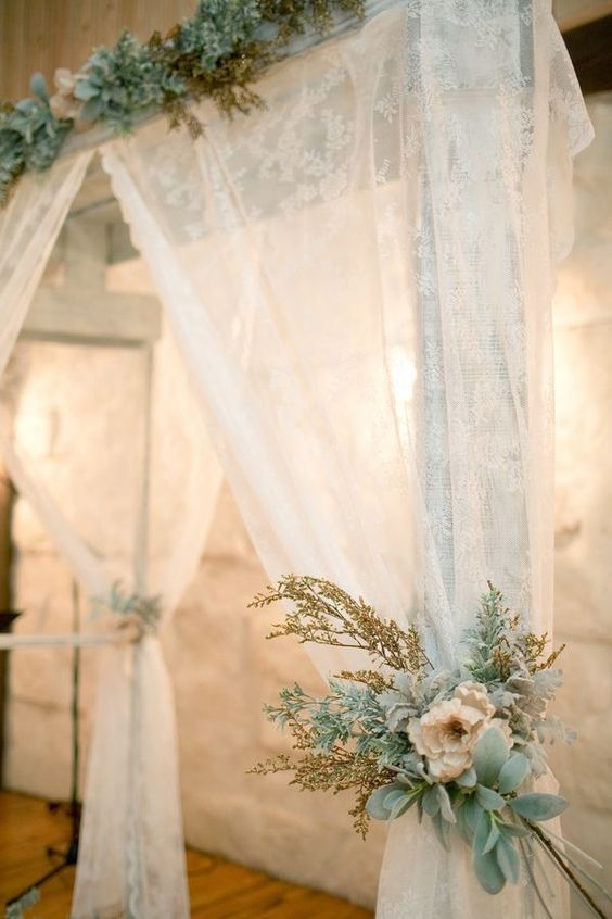 a wedding altar with lace curtains, pastel blooms and pale greenery and herbs is a fantastic idea for a wedding