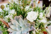 a wedding centerpiece with a wooden box planter, some blooms and berries, greenery and a pale succulent