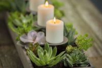 a wooden tray with succulents and greenery plus candles on stands is a cute vintage meets rustic centerpiece