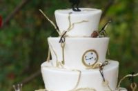 an Alice in Wonderland wedding cake decorated with keys, clocks, greenery and a fun rabbit topper