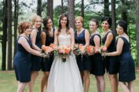 bridesmaids wearing knee navy dresses with thick straps and coral shoes plus updos for an elegant look