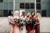 mismatching boho bridesmaids’ dresses in red, pink, grey and dusty pink for a boho fall wedding