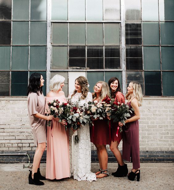 mismatching boho bridesmaids' dresses in red, pink, grey and dusty pink for a boho fall wedding