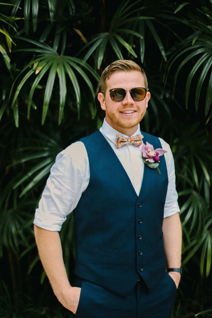 stylish navy pants, a waistcoat and a colorful bow tie plus a bright floral boutonniere for a summer or tropical look