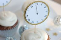 wedding cupcakes topped with gold glitter edge clocks are cute and chic for a NYE wedding