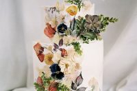 a beautiful wedding cake inspired by Dutch Masters – a white wedding cake with pressed edible flowers and leaves is very chic