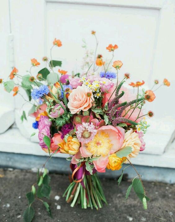 a bright wedding bouquet of blush, yellow, violet and orange blooms, greenery and astilbe is amazing for summer