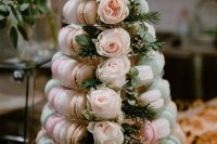 a clear stand with light pink, blush, neutral and green macarons, with blush roses and greenery is a beautiful alternative to a usual wedding cake