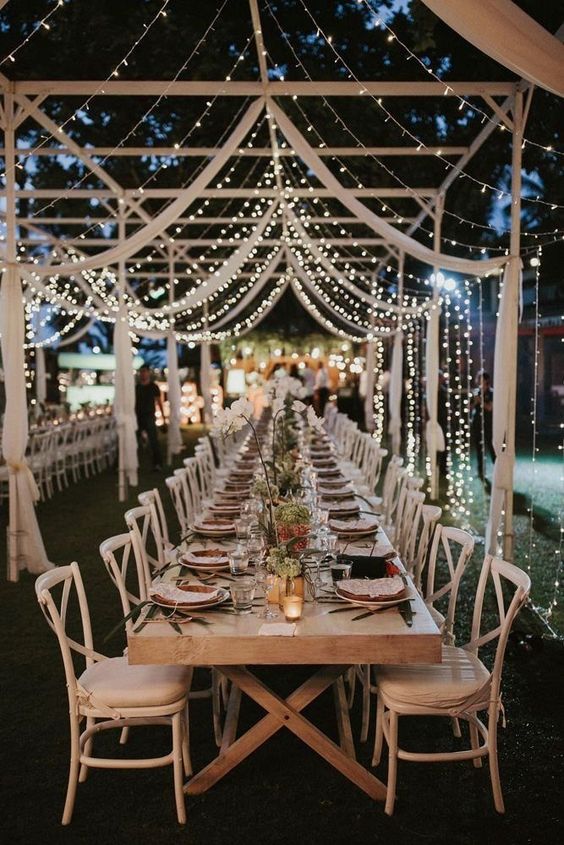 a delicate canopy formed with airy white fabric and lights make the space beautiful, chic and subtle