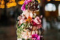 a glass stand with blush macarons that compose a tower, with bright blooms and greenery is a gorgeous idea for a bright wedding