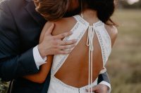 a gorgeous modern boho fitting wedding dress with lace appliques, a halter neckline, a keyhole back on ties is a lovely idea
