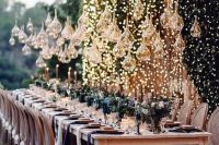 a lights wall and whimsically shaped glass candle holders over the table make the reception glam and very chic