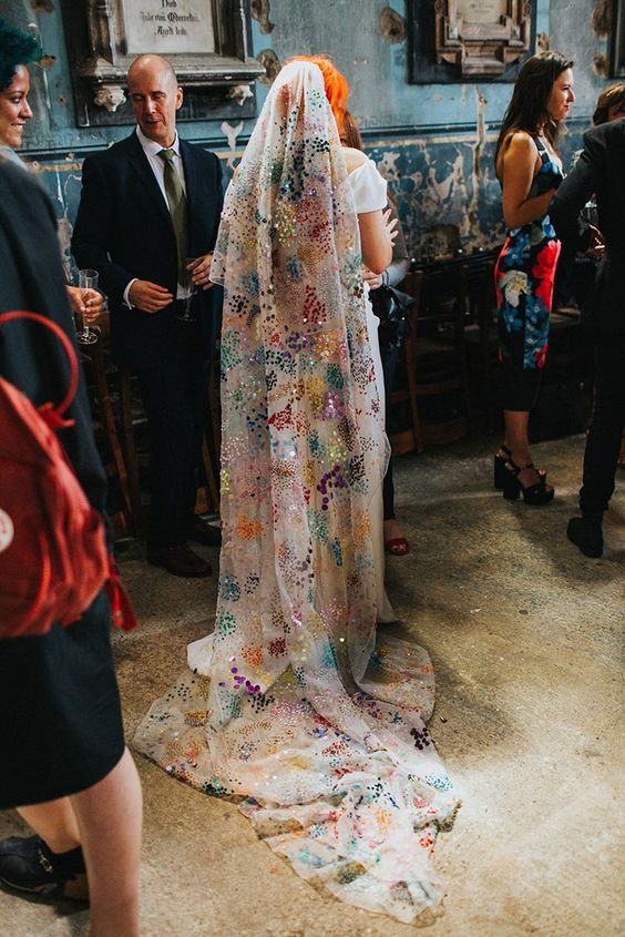a long wedding veil accented with super colorful sequins is a jaw-dropping idea and a cool way to add color to the look