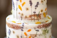 a lovely naked wedding cake with pressed flowers and leaves is great for a boho or relaxed flower-filled wedding