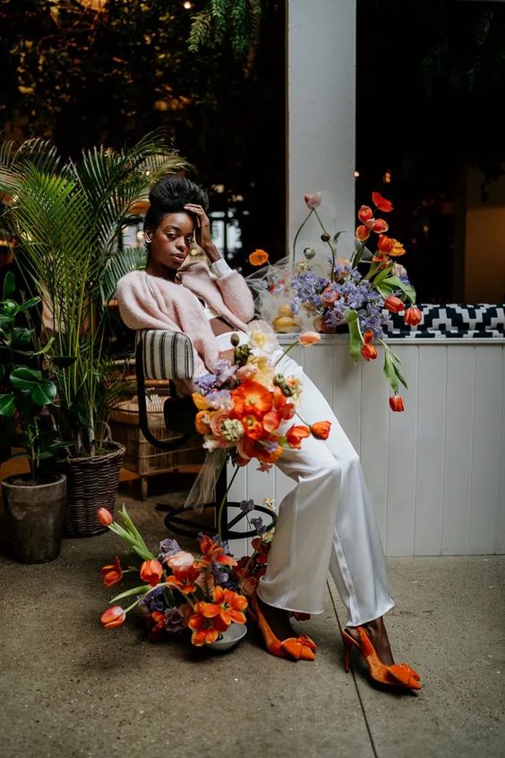 a neutral bridal look done with bold orange shoes and bright blooms all around create a fresh and bold spring wedding space