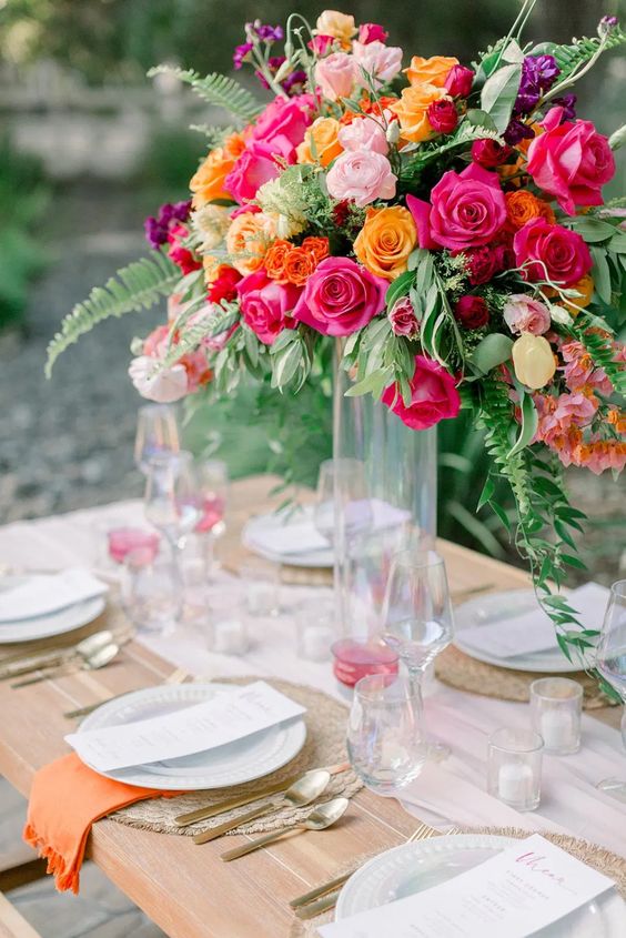 a neutral wedding tablescape with orange napkins and super bold blooms is a fantastic idea to enjoy color