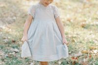 a powder blue knee flower girl dress with white shoes and a greenery crown is a chic and cute idea