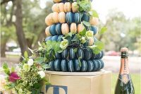 a refined macaron tower of navy and blush macarons, with greenery and privet berries is a gorgeous idea for a modern wedding