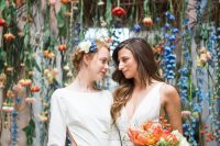 a unique wedding backdrop made of colorful blush, red, orange and blue blooms and berries looks and feels very natural and organic