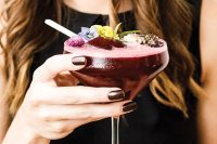 a wedding cocktail with a popsicle and edible flowers will give a decadent feel to your wedding