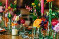 a wedding tablescape accented with super colorful flowers, pink candles and orange napkins looks vibrant