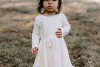 a white plain and boho lace flower girl dress with long sleeves, white flats and a floral crown for a boho chic look