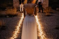 lights lining up the aisle are a gorgeous idea for an evening wedding ceremony and they won’t break the bank