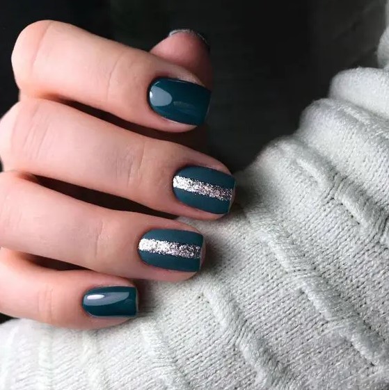 shiny and matte teal nails with silver glitter stripes in the middle to embrace the season and make a colorful statement