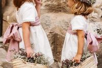 white over the knee flower girl dresses with pink sashes and bows, floral crowns and woven bags with blooms