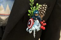 a Captain America wedding boutonniere with a feather, greenery and berries is a creative idea for a big fan