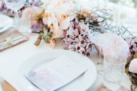 a beautiful beach wedding centerpiece with succulents, corals, peachy orhicds, branches and pink quartz
