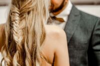 a beautiful boho half updo with a double braided halo, a fishtail braid, waves down and a delicate embellished hair vine