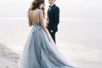 a beautiful grey wedding ballgown with a layered tull skirt, a lace bodice with a cutout back and a sash for a romantic look