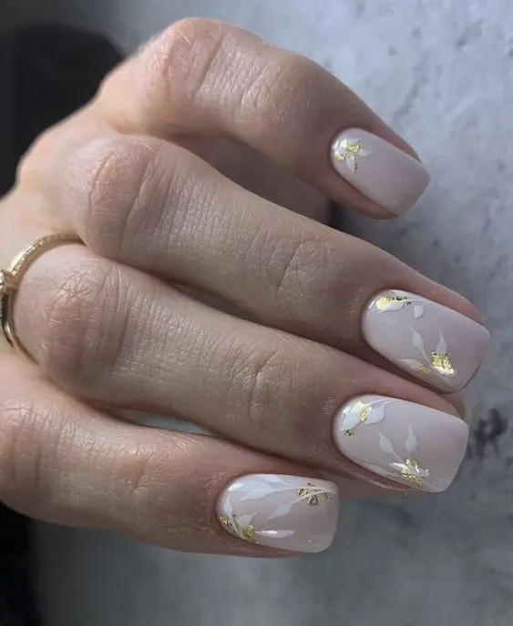 a blush wedding manicure with botanical patterns and gold foil is amazing for a spring or summer wedding